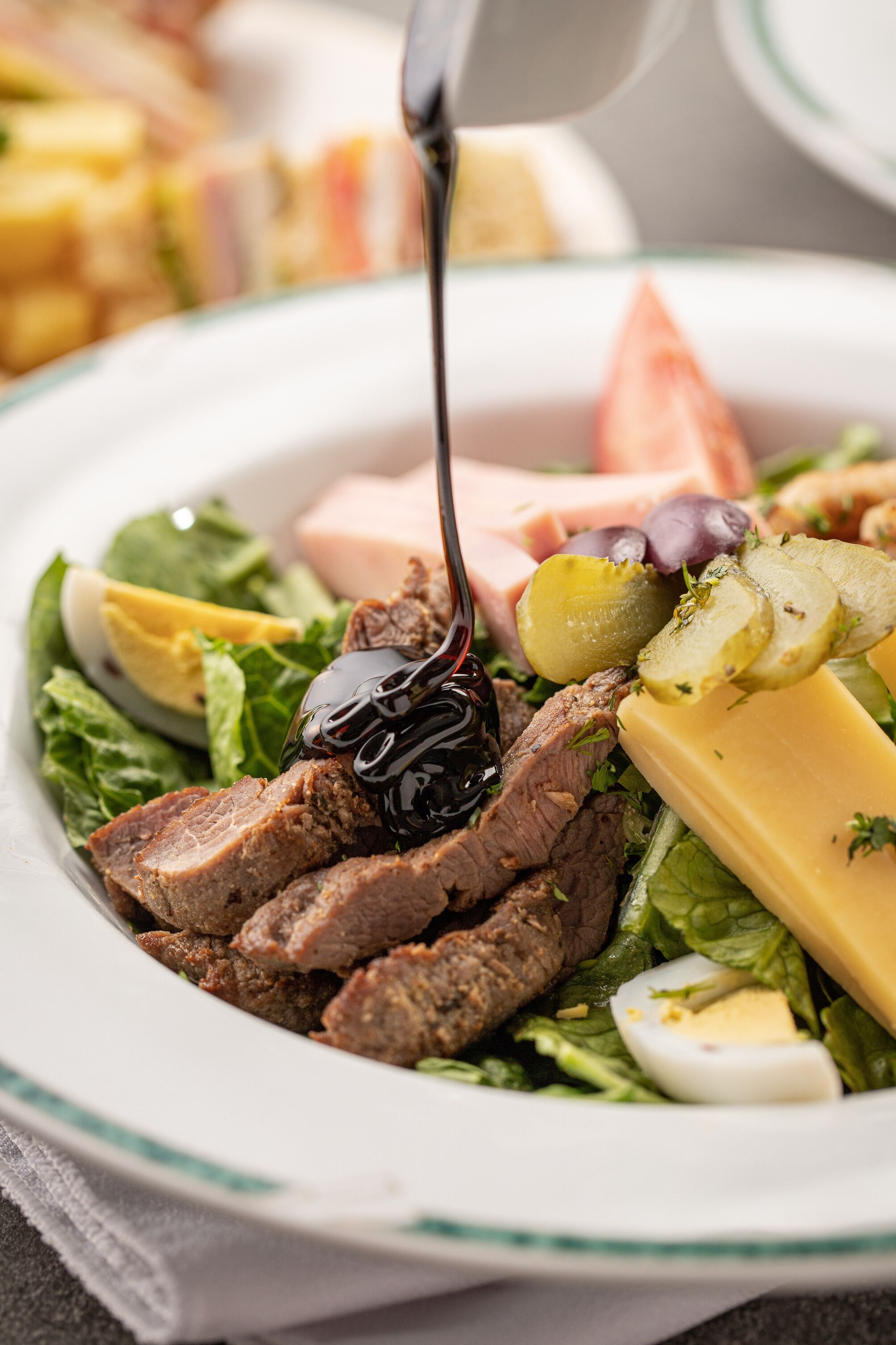 Ensalada con diversos ingredientes, incluyendo carne, queso y verduras.