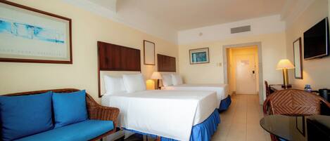 Una habitación de hotel con cama, sofá, mesa de comedor y televisor.