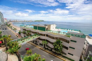 Na praia, espreguiçadeiras, guarda-sóis, toalhas de praia 