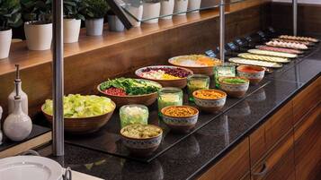 A buffet with various dishes and condiments.