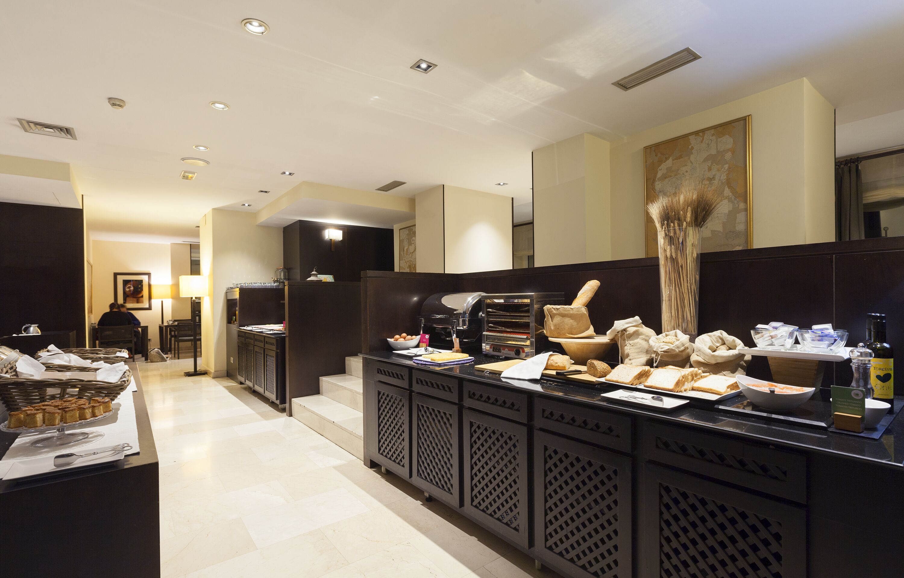 Cocina de hotel con una barra de buffet, que incluye diversas opciones de comida y una estación de café.