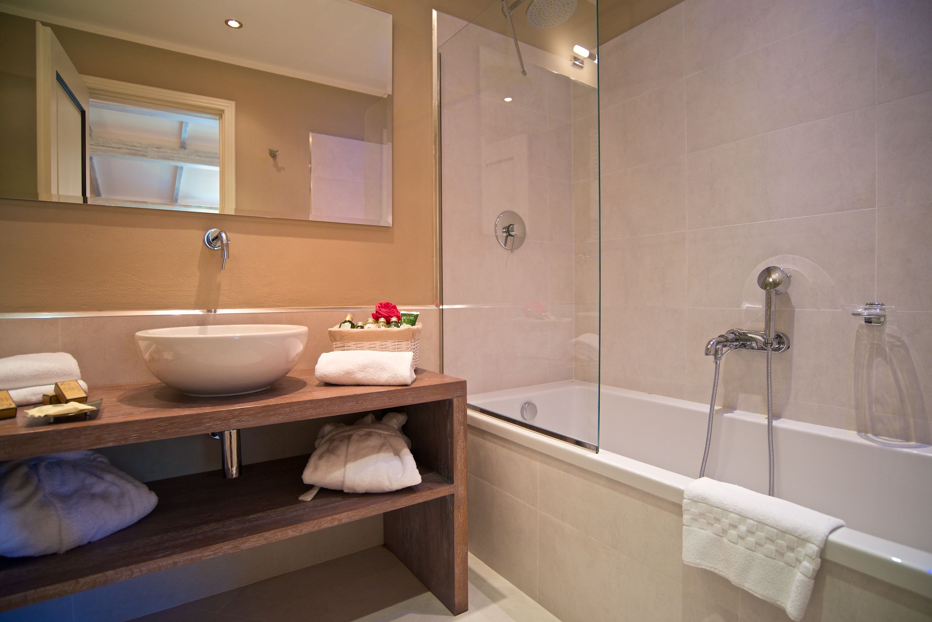 Un baño moderno con un lavamanos grande, una bañera y una ducha con cerramiento de vidrio.