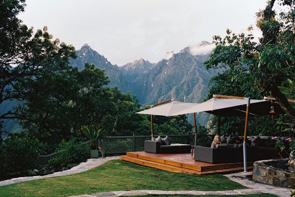 An outdoor seating area with a view of a mountain range.