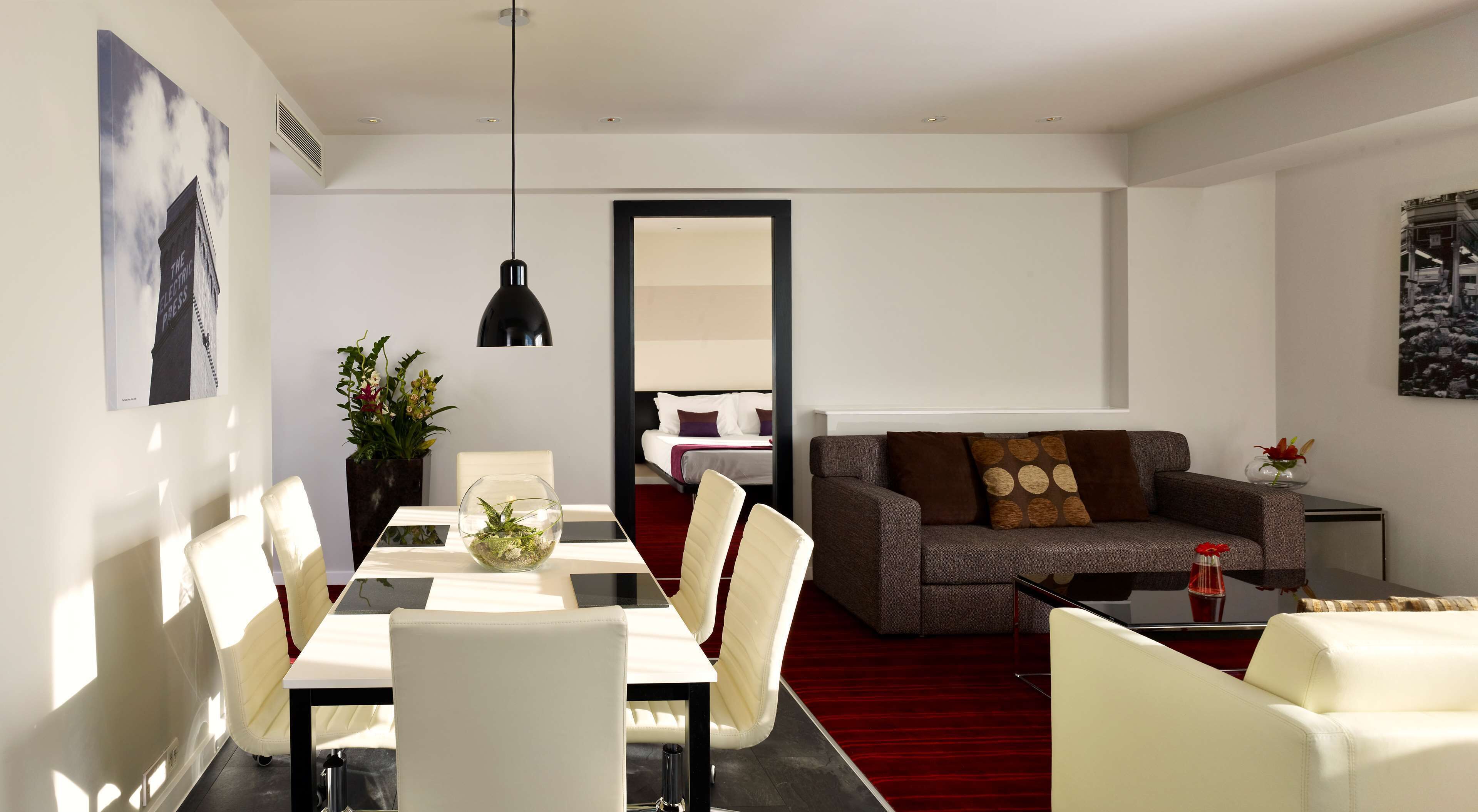 A modern living room with a dining area, a sofa, and a coffee table.