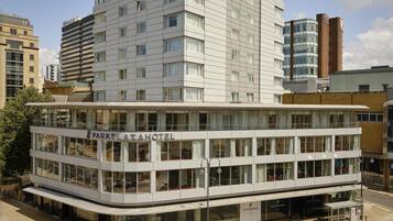 A multi-story hotel with a prominent sign reading 'PARKPLAZA HOTEL' and a modern architectural design.
