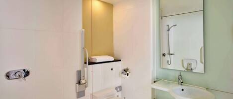 A modern bathroom with a toilet, sink, and mirror.