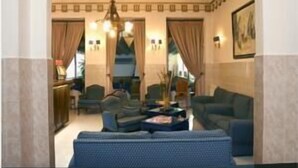 A spacious living room with a high ceiling, a chandelier, and a large window with curtains. - Costa do Sol Residencial (Porto)