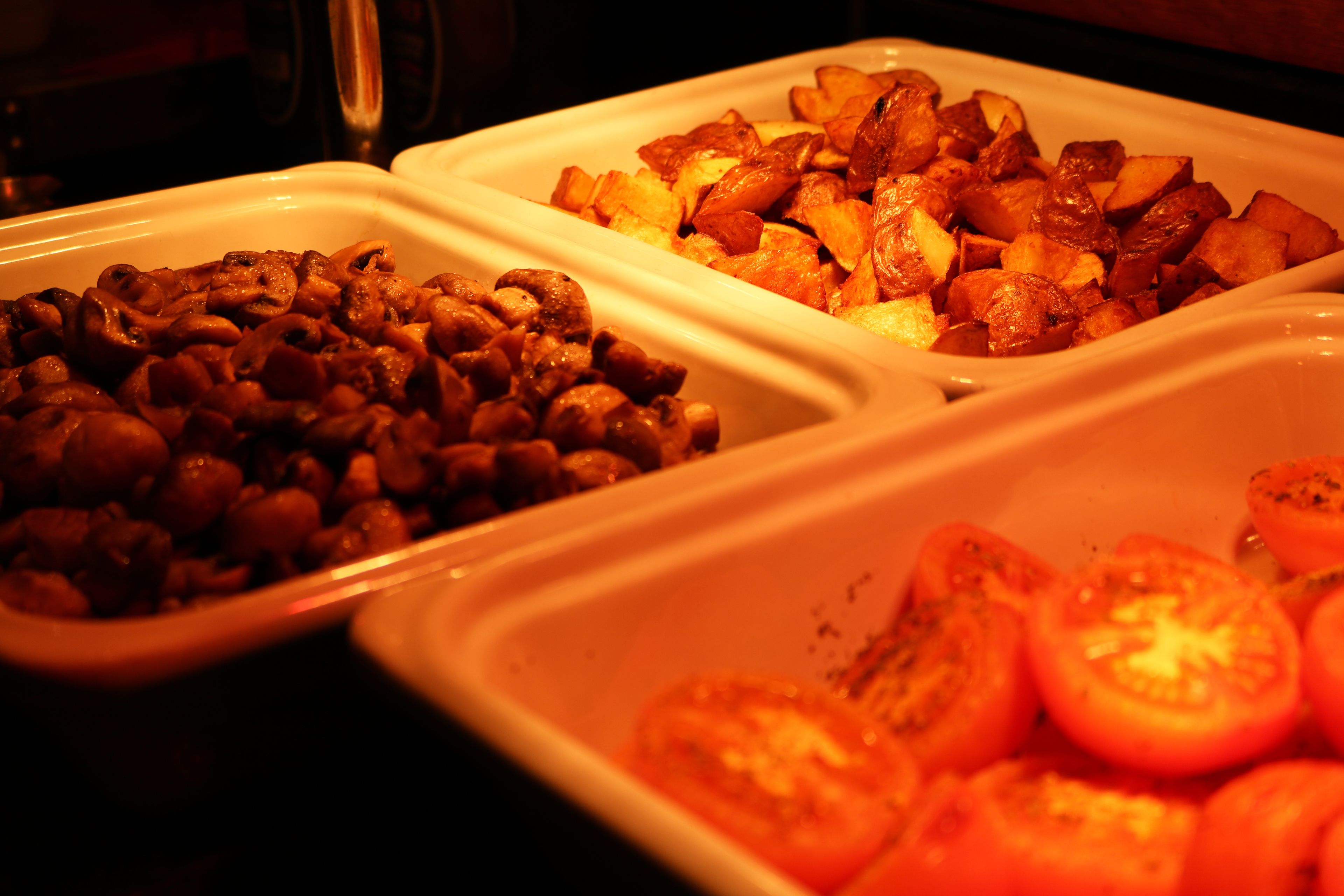 Drie schalen met champignons, aardappelen en tomaten.