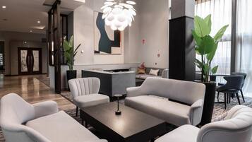 Un vestíbulo moderno con una recepción, zona de estar y ventanas amplias.
