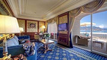 Ein luxuriöses Zimmer mit blauem Teppichmuster, einer Couch, einem Couchtisch und einem Fernseher.