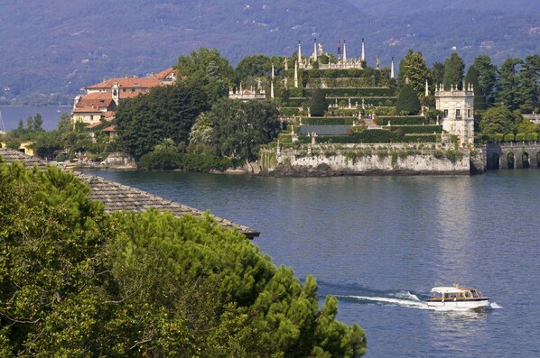 A boat on a calm lake with a castle in the background. - Grand Hotel Bristol (Stresa)