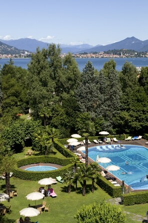 Una piscina al aire libre de temporada, sombrillas