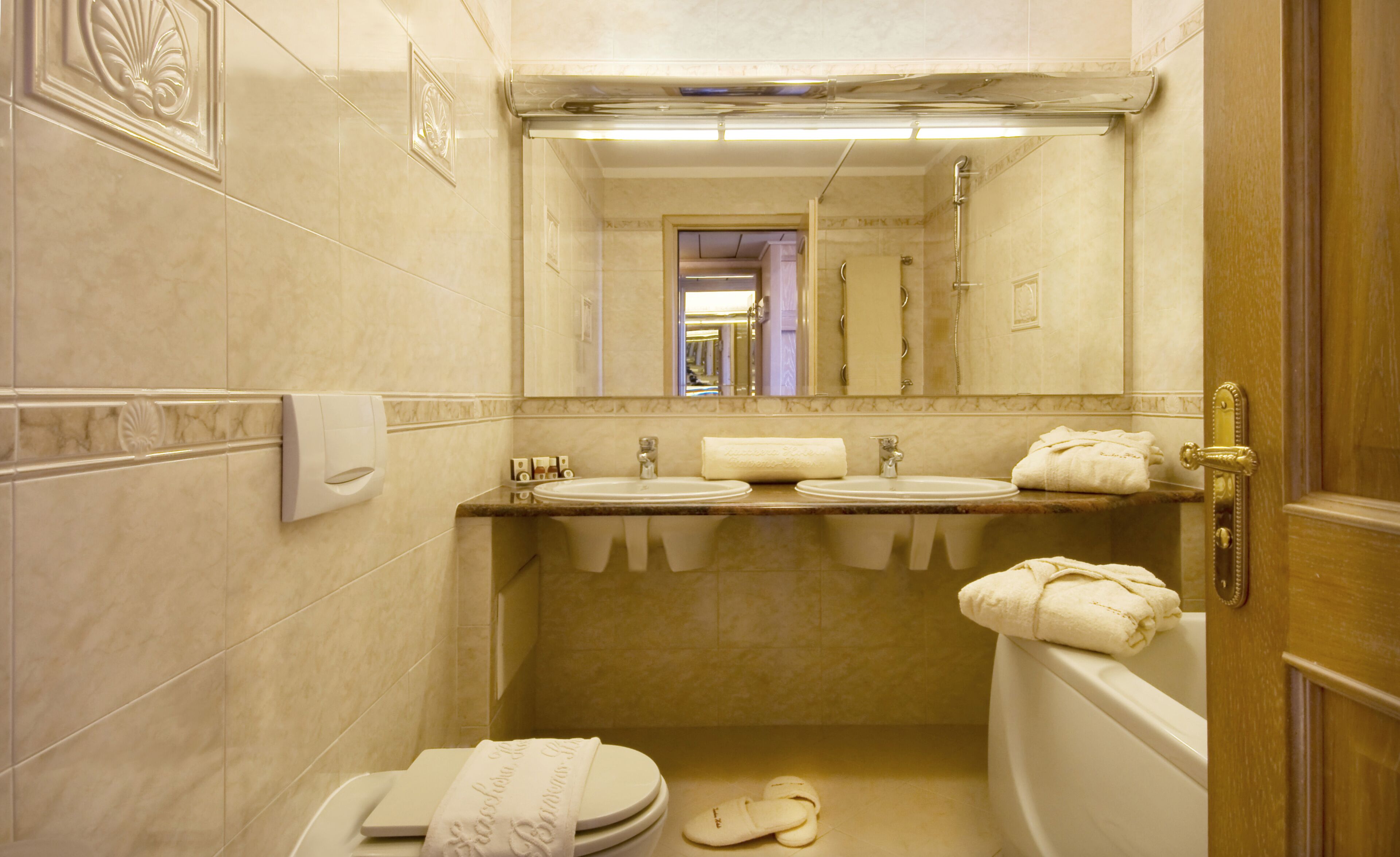 A bathroom with two sinks, a toilet, and a bathtub.