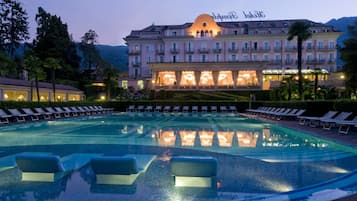 Una piscina al aire libre de temporada, sombrillas