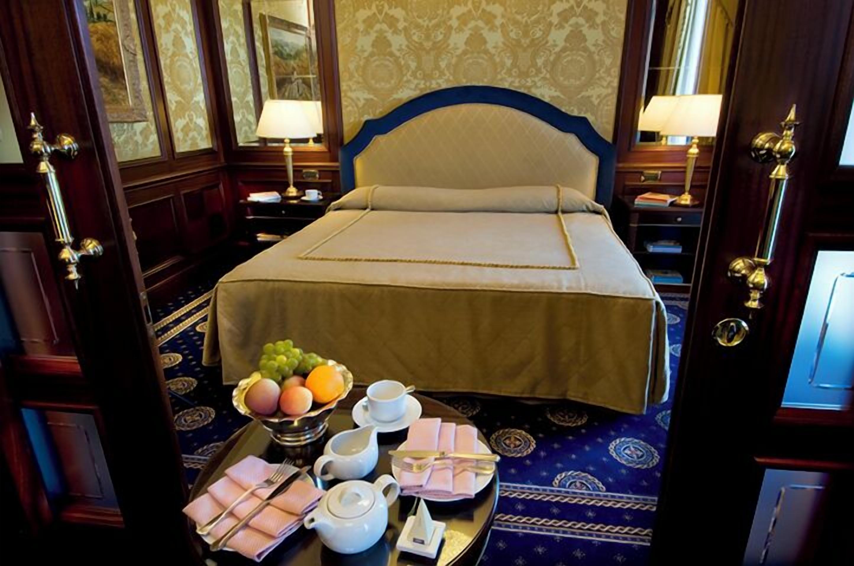 Ein Hotelzimmer mit einem großen Bett, einem Tablett mit Frühstücksgegenständen und einer Wanddekoration.