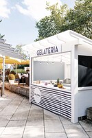 Una heladería con fachada blanca y un cartel que dice 'GELATERIA'.