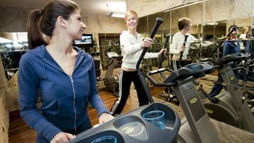 A gym with exercise equipment and mirrors.
