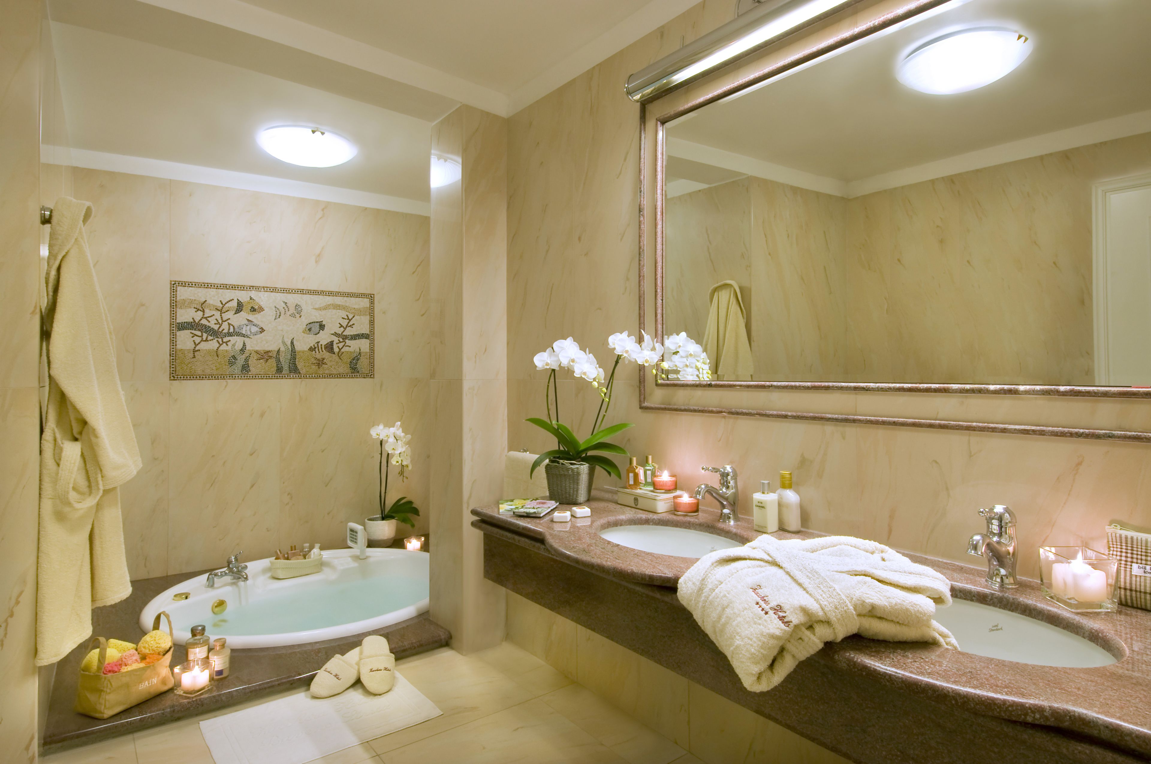 A bathroom with a bathtub, two sinks, a large mirror, and a towel rack.