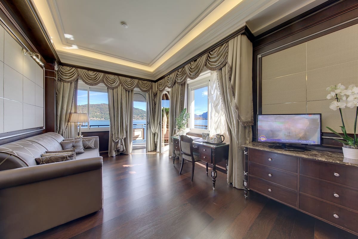 A spacious living room with a sofa, a desk, and a television.