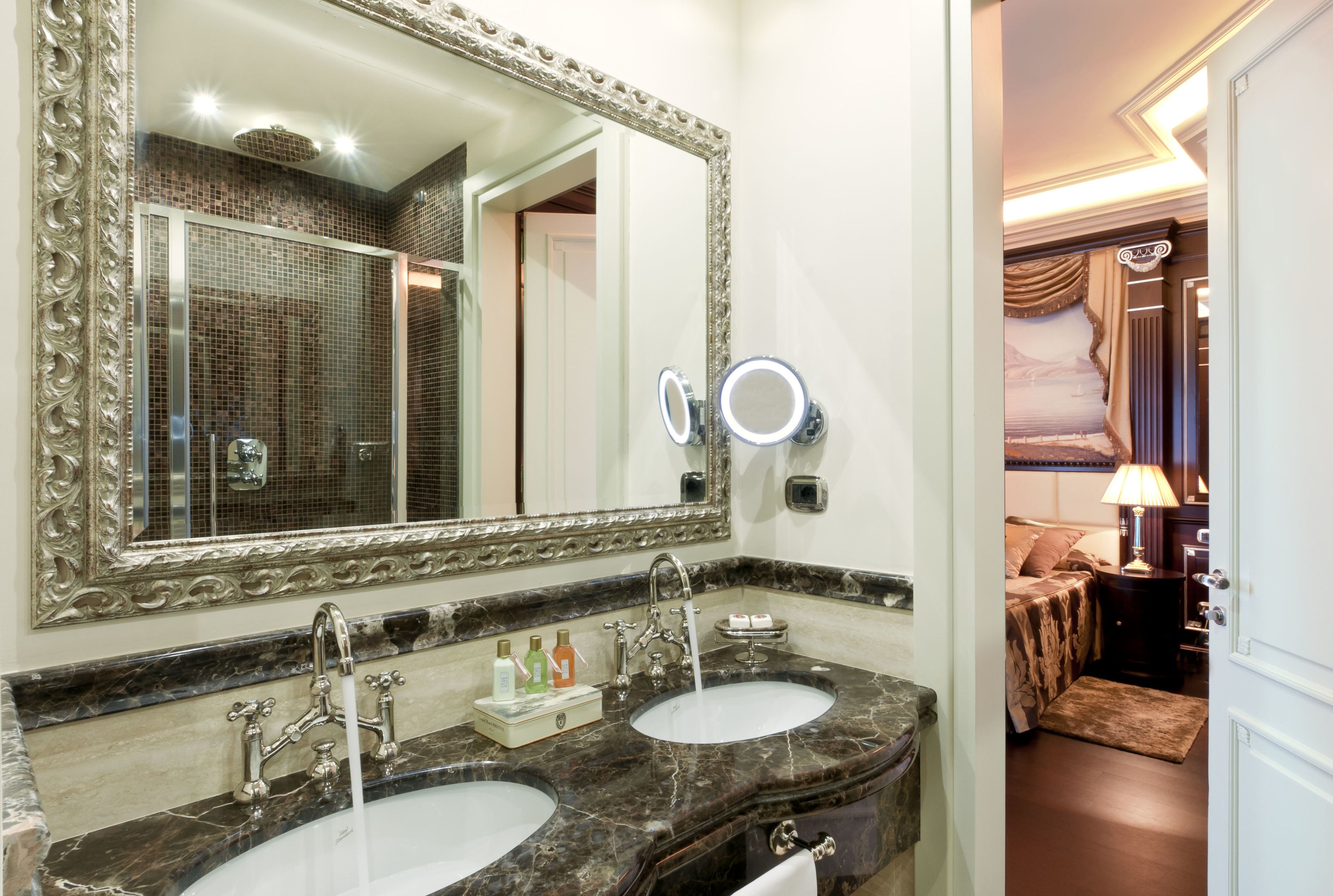 Un baño con dos lavamanos, un espejo grande y una zona de tocador.