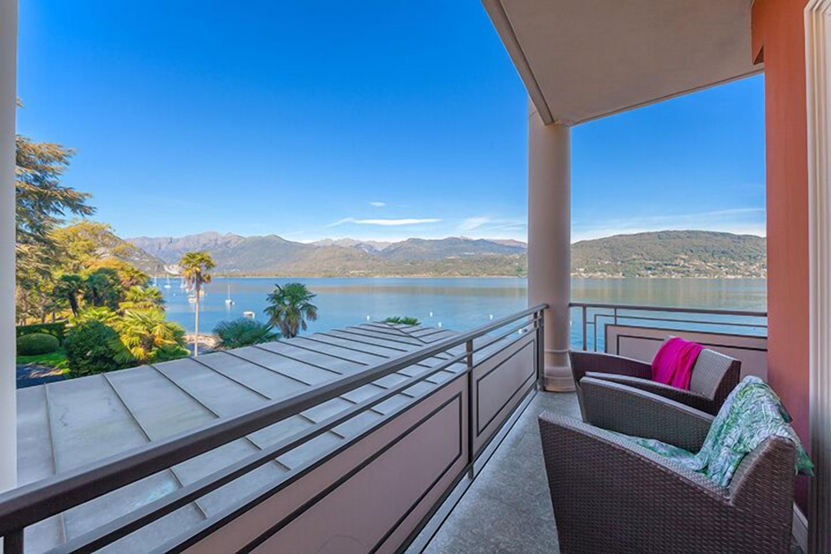 A balcony with a view of a lake and mountains.