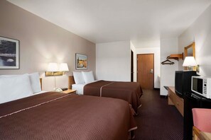 A hotel room with two beds, a desk with a lamp, a TV, a microwave, and a door leading to another room. - Travelodge by Wyndham Elko NV (Elko)
