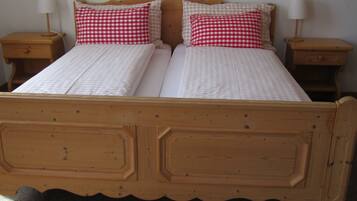 Un lit double avec un cadre en bois, deux tables de chevet et un tableau accroché au mur.