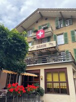 Un edificio con un letrero que dice 'BÄREN' y una bandera suiza.