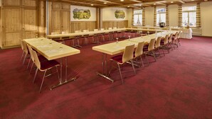 A conference room with long tables and chairs, wooden walls, and a red carpet. - Hotel Bären - The Bear Inn (Wilderswil)