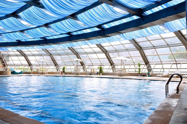 An indoor swimming pool with a glass ceiling and multiple lounge chairs. - Narada Grand Hotel Hangzhou Westlake (Hangzhou)