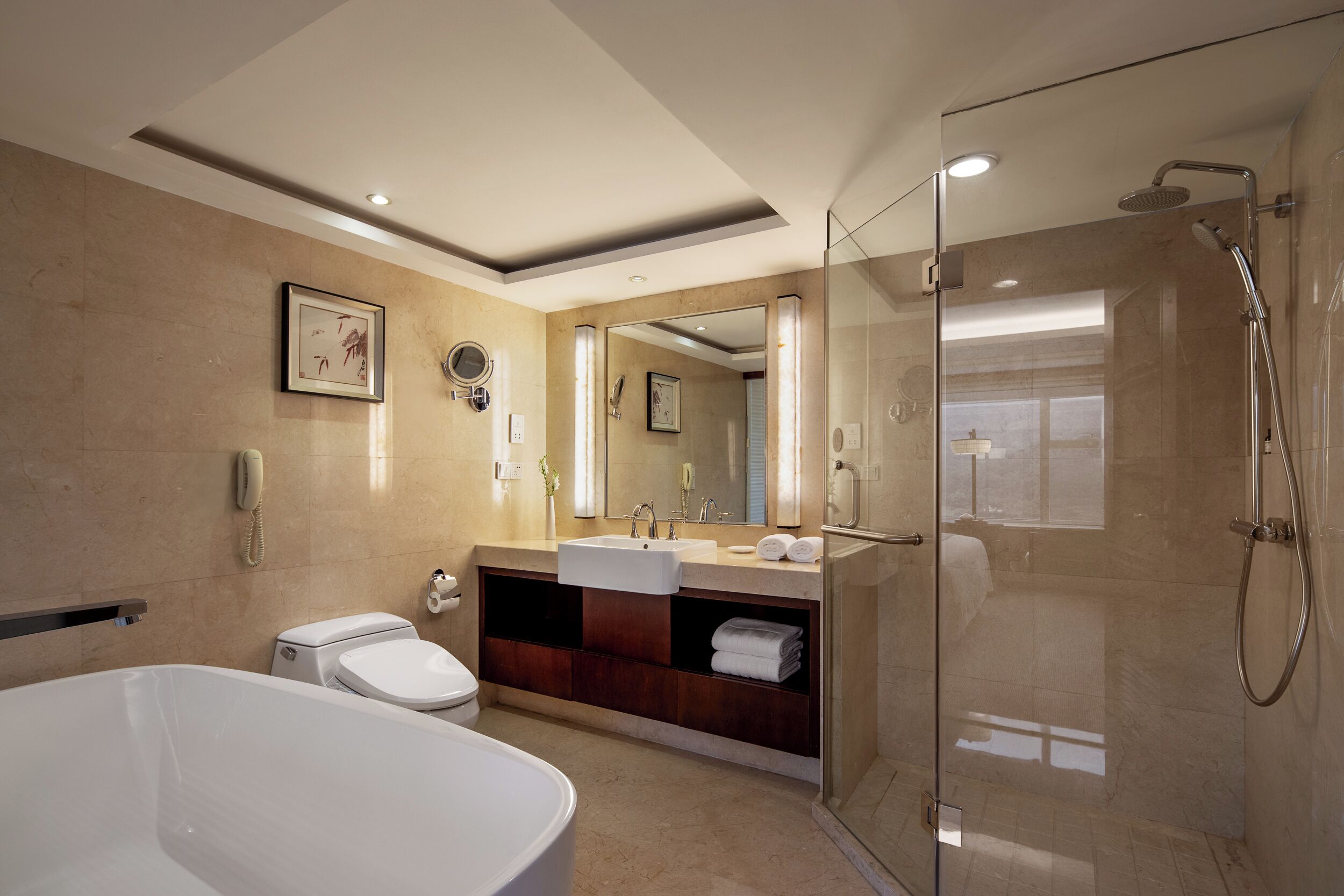 Un baño moderno con ducha de vidrio, una bañera independiente y un tocador con espejo.