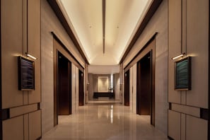 A modern hallway with a reflective floor, recessed lighting, and framed artwork on the walls. - Narada Grand Hotel Hangzhou Westlake (Hangzhou)