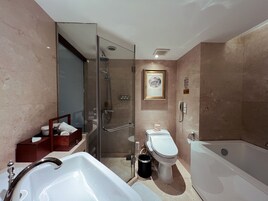 Un baño moderno con ducha envuelta en vidrio, bañera, inodoro y bidé.