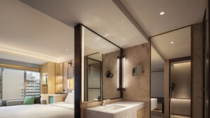 A modern hotel room with a large bed, a bathroom with a marble vanity, and a large mirror. - Zhejiang Narada Grand Hotel (Hangzhou)
