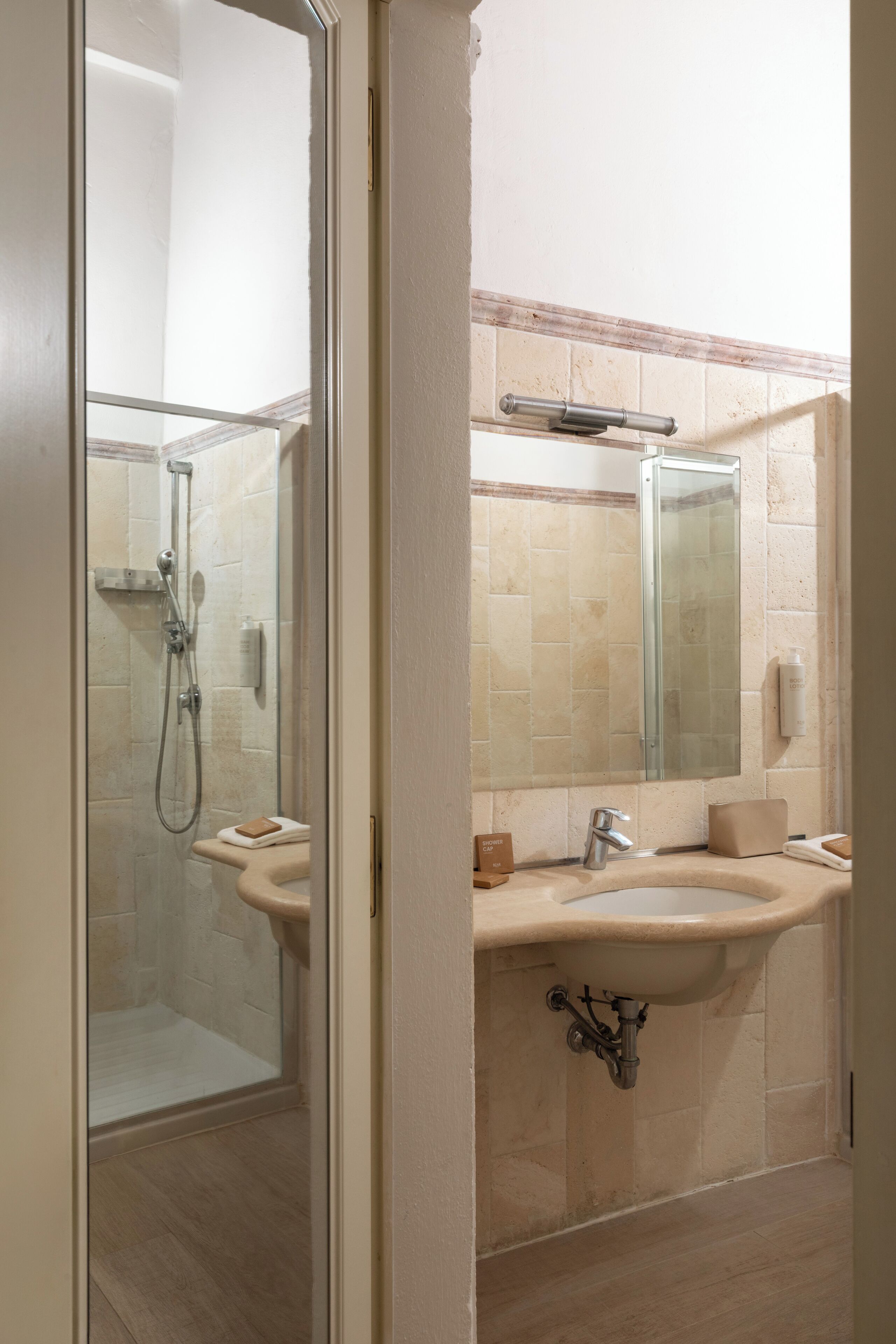 Une salle de bain avec une douche à parois de verre, un lavabo, un miroir et un porte-serviettes.