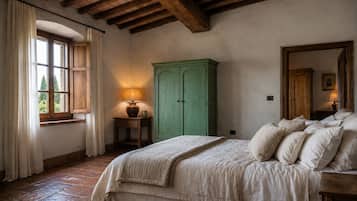 A bedroom with a bed, a green cabinet, a window with curtains, and a lamp on a nightstand.