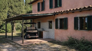 Ein Haus mit überdachter Terrasse, einem Golfwagen und einer gefliesten Küchenzeile.