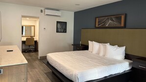 Una habitación de hotel con una cama, un escritorio y una silla.
