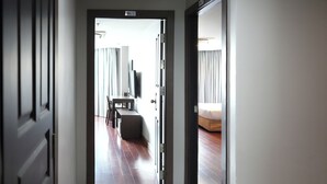 Corridoio di un albergo che conduce a una camera da letto con un letto e una televisione.