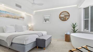 A modern bedroom with a bed, bedside table, and a round wooden shelf.