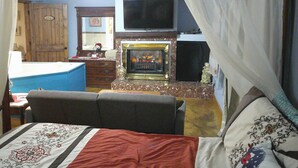 A bedroom with a bed, a television mounted above a fireplace, a dresser, and a door labeled "LADY". - Lil Black Bear Inn (Nashville)