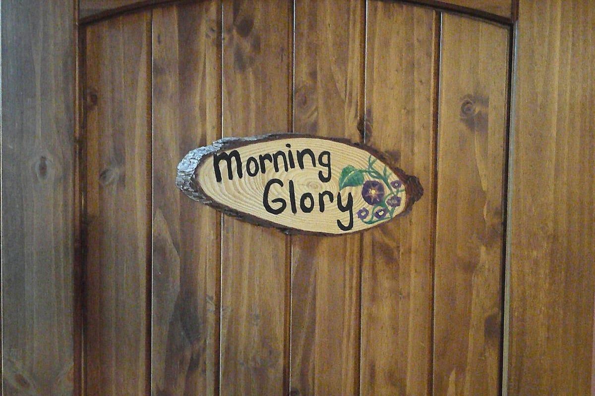 Eine Holztür mit einem Schild, auf dem 'Morning Glory' steht.