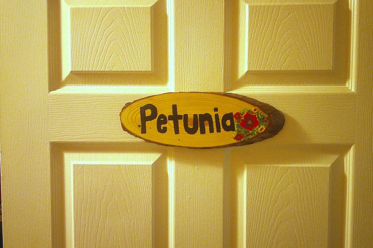 Eine Tür mit einem Schild, auf dem 'Petunia' steht, und einer kleinen floralen Dekoration.