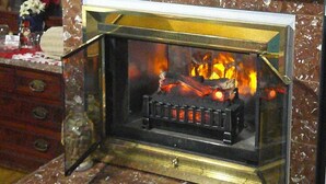A fireplace with a television mounted above it. - Lil Black Bear Inn (Nashville)
