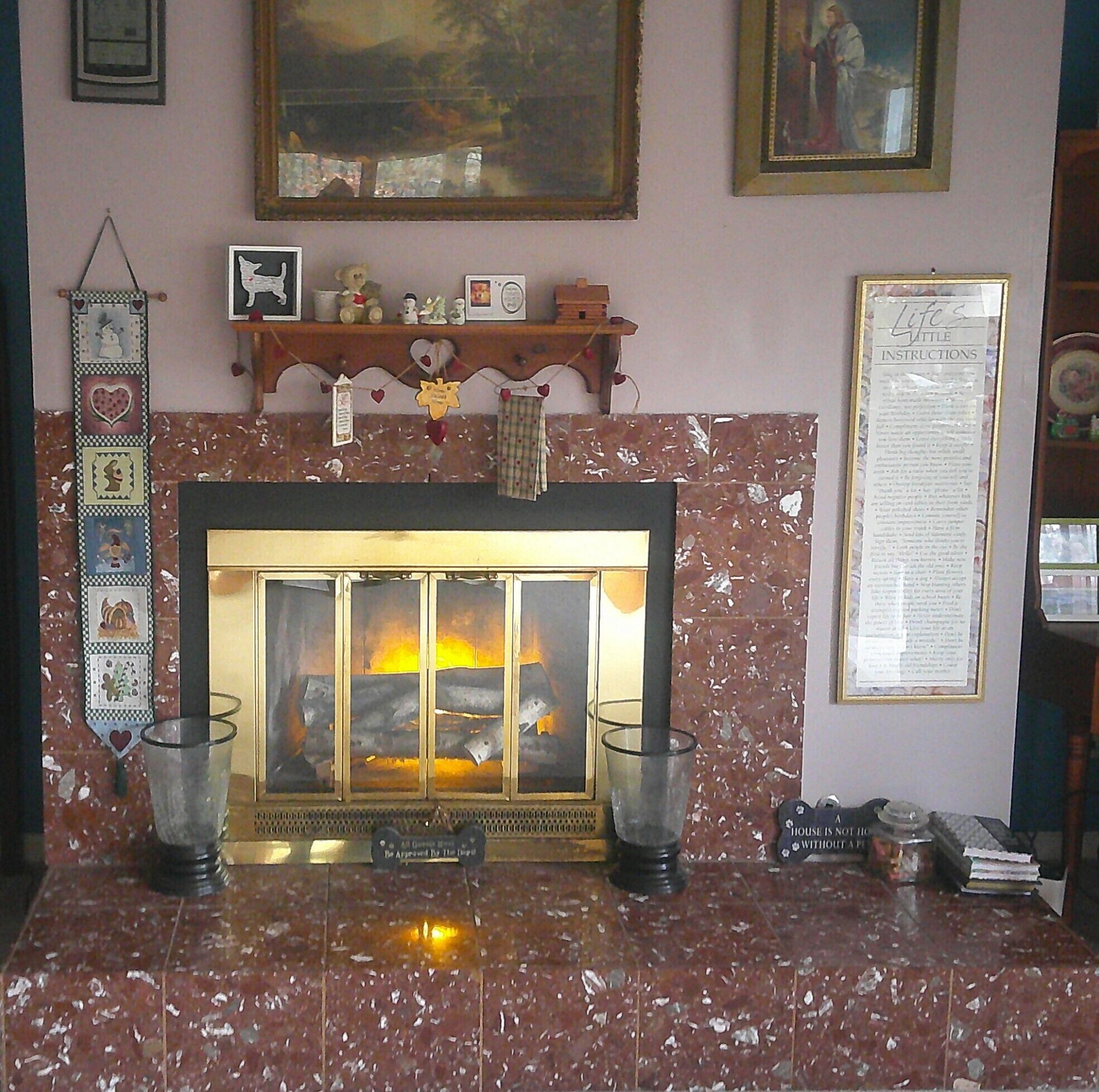 A fireplace with a mantel decorated with various items, including a framed picture, a small statue, and a candle holder.
