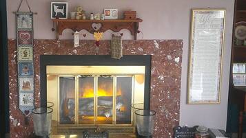 A fireplace with a mantel decorated with various items, including a framed picture, a small statue, and a candle holder.