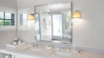 Une salle de bain moderne avec deux lavabos, un grand miroir et un espace douche.