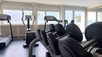 Un gimnasio con cintas de correr, elípticas y bancos de pesas.