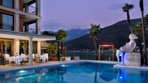 Ein Schwimmbecken mit Essbereich und Bergblick.