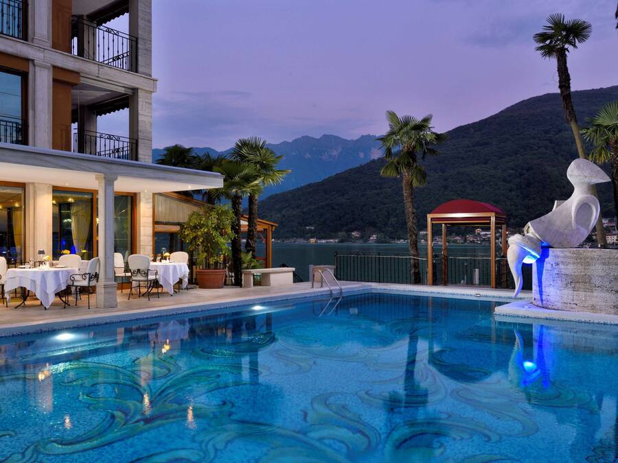 A swimming pool with a dining area and a view of mountains.